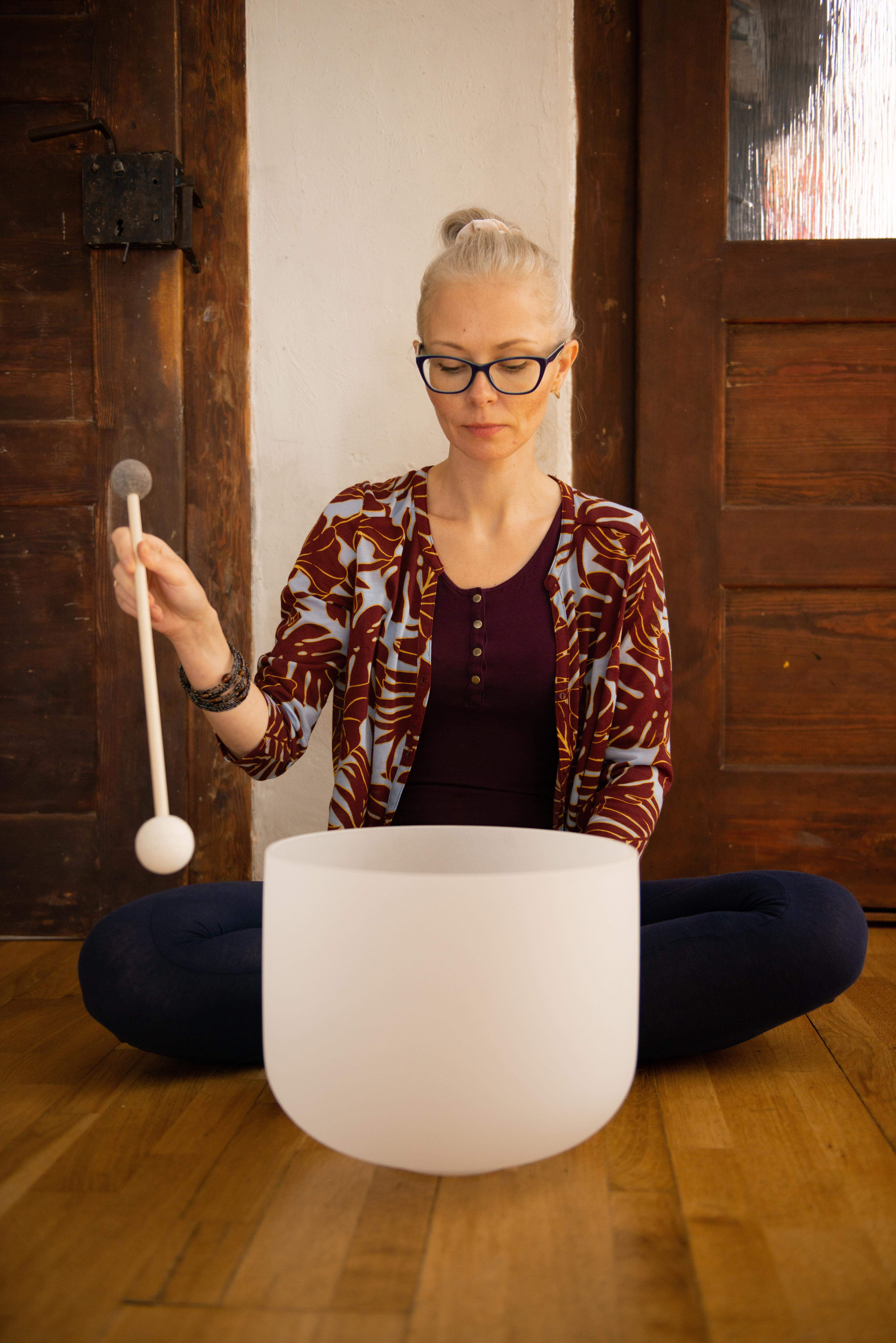 misa kryształowa, obok kobieta w okularach uderza w misę